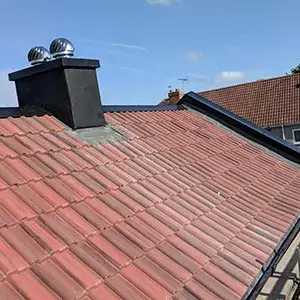 The roof of a house with a chimney.