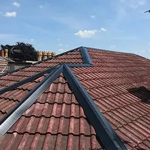 A red tiled roof with a wind vane on top of it.