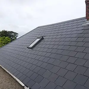 A black slate roof with a skylight on top of it.