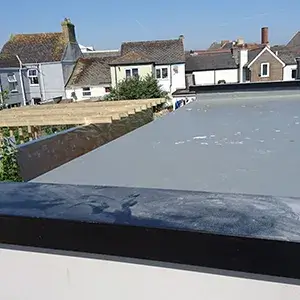 A view of a rooftop with houses in the background.