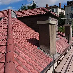 A view of a red tiled roof with a sky background.