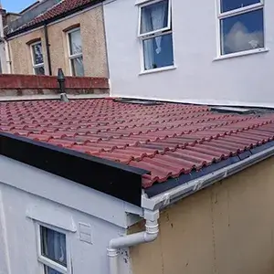 A red tiled roof on a white building.