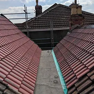 A couple of red tiled roofs sitting next to each other.